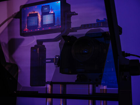 Mirrorless camera rig filmed through teleprompter glass with external monitor
