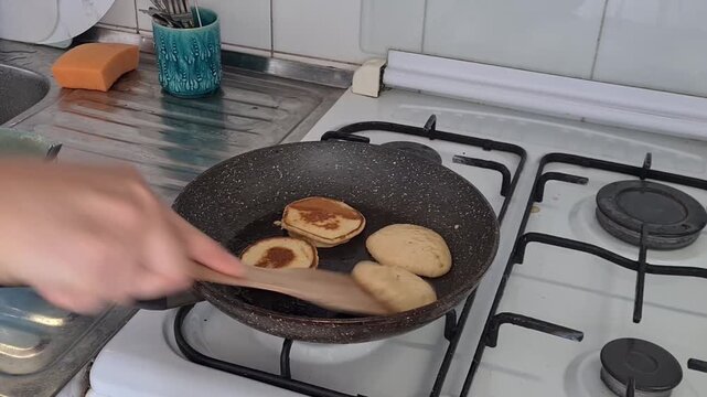Cooking pancakes in a kitchen with a person flipping them in a