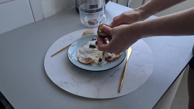 Making breakfast with pancakes, yogurt, and blueberries in a kitchen