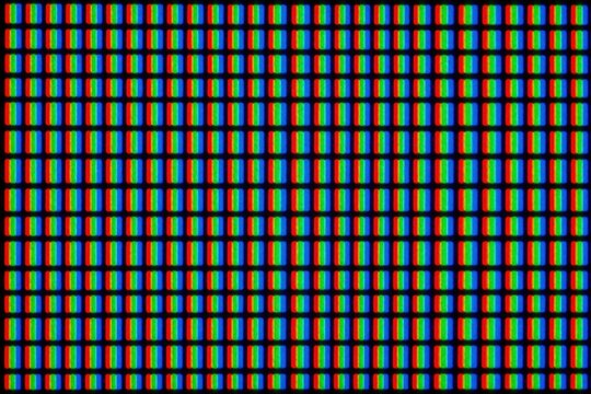 Macro view of RGB subpixel grid on modern LED TV screen. Red green, blue light dots form digital matrix pattern. Colorful pixel array shows electronic display texture. Close up of high tech monitor