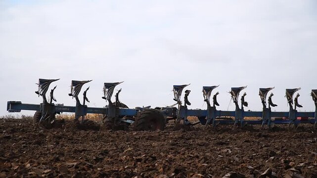 Reversible cultivator. Modern tractor with reversible plow plows the field. Soil cultivation with a cultivator. n