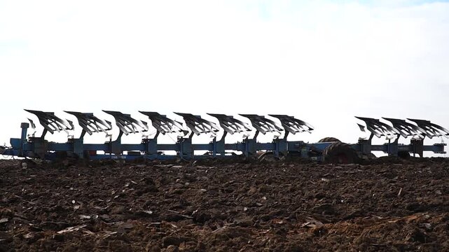 Reversible cultivator. Modern tractor with reversible plow plows the field. Soil cultivation with a cultivator. n