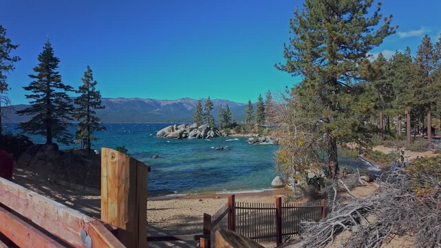Scenic cove at Lake Tahoe with clear water, rocks, and mountain landscape in California. Natural lakeshore view with trees and beach access, ideal for travel and outdoor use