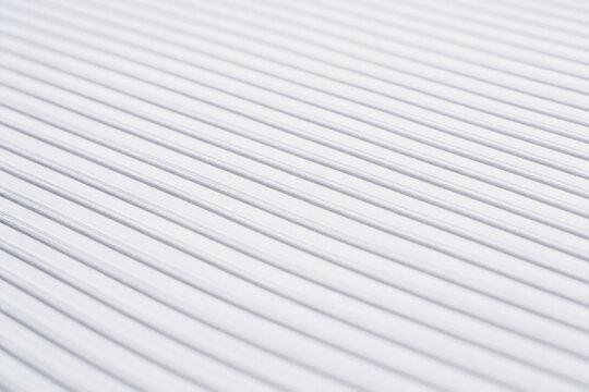 A plain white flat surface with subtle parallel diagonal linear textures, forming a clean uniform pattern.