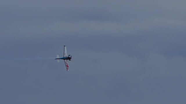 Propeller plane doing stunts at airshow with smoke trails