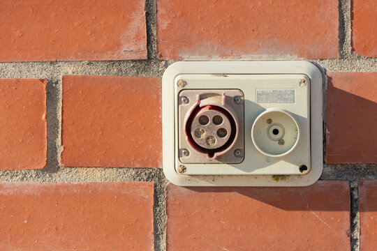 Industrial electric socket on red brick wall