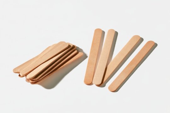 Minimalist pile of wooden coffee stirrers on a bright surface