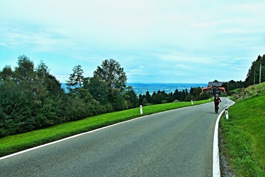 Austria - view on the cyclist on the road to the Burghof Sadlerin in Bregenzwald