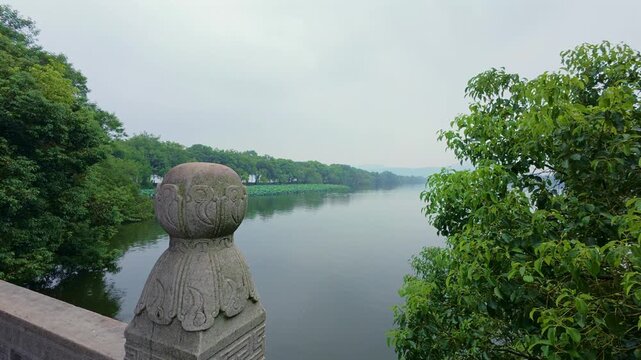 Ornate stone finial on a lakeside railing overlooking West Lake, Hangzhou, China