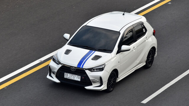High angle shot of a white Astra Toyota Agya hatchback driven on the toll road