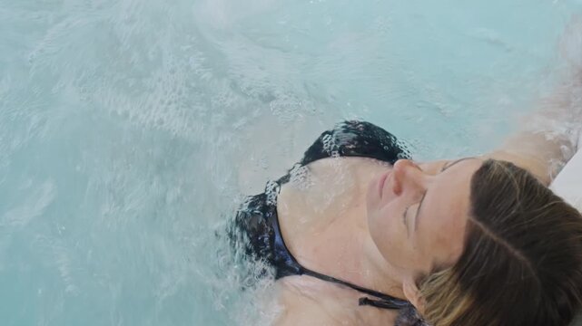 Woman relaxing in bubbling water, enjoying massage in hot tub