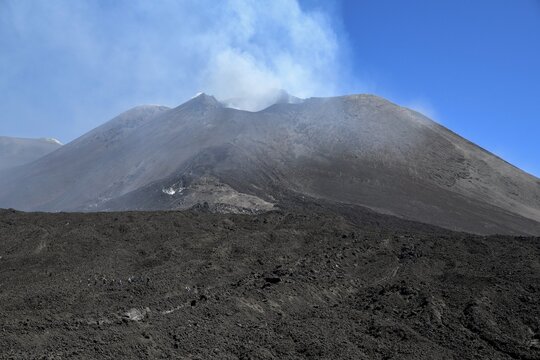 Hiking group below the smoking crater of the volcano Etna, Province of Catania, Sicily, Italy