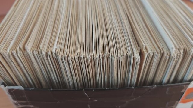 Macro view of a crate full of antique LPs. Numerous vinyl records with aged paper covers standing vertically in a large collection