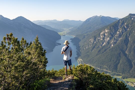Hiker looks into the distance, view from B&auml;renkopf to Achensee, left Seekarspitze and Seebergspitze, right Rofangebirge, Karwendel, Achensee, Tyrol, Austria