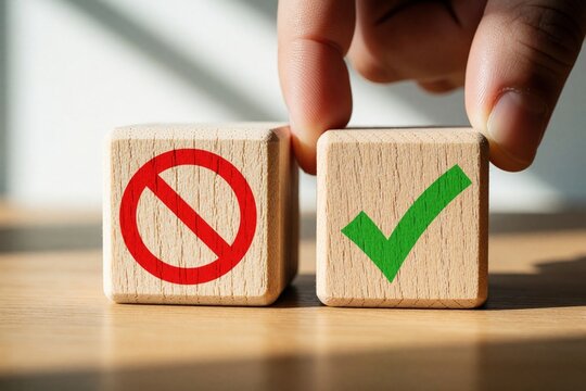 Hand places wooden block with no symbol next to checkmark block. Person makes choice between wrong, right options. Business decision making concept using wooden cubes on desk. Concept of selection
