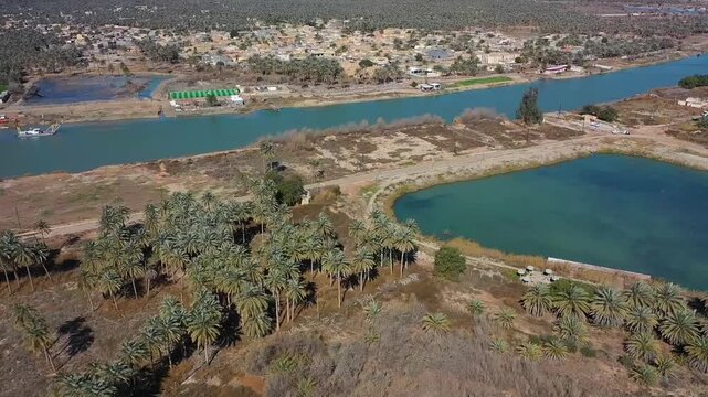 Aerial view of a lake and palm trees beside the ruins of Babylon, Iraq