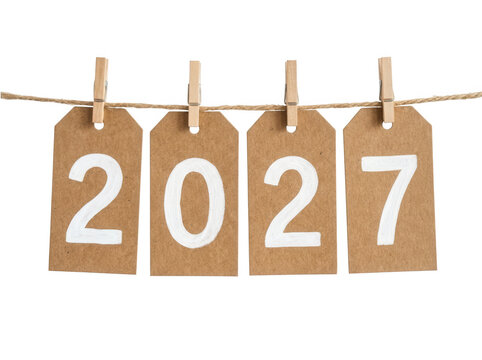 Kraft paper gift tags with numbers 2027 hanging on string isolated background