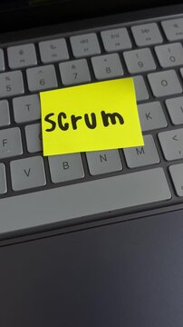 Scrum sticky note on laptop keyboard close up