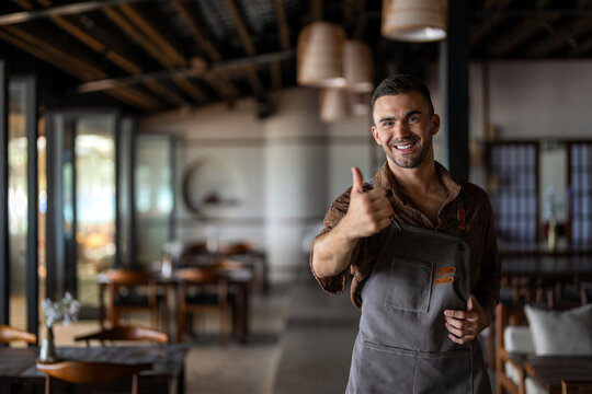 Successful cafe owner giving thumbs up as a sign of approval and quality service