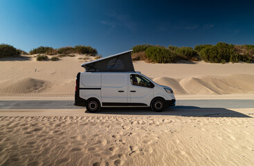 White camper van with pop roof parked by sand dunes Tarifa Spain © Paolo Corazza