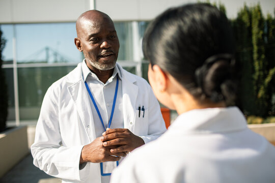 Doctor talking with colleague outside hospital
