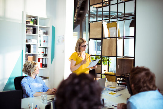 Woman leading team meeting with notes in open office