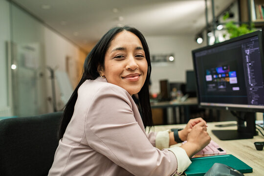 Smiling woman at computer in modern office