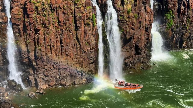 Iguazu Falls, Brazil, tourist boat cruising near massive waterfalls and rocky cliffs