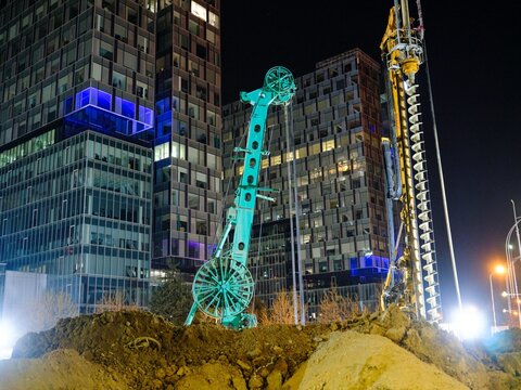 Construction of piața presei libere metro station in bucharest shows tunnel drilling equipment amid urban development at night