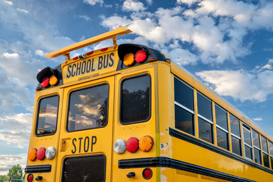 rear end of a yellow shcool bus with wraning lights and emergency exit door
