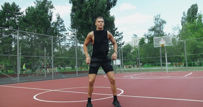 Athletic man has workout outdoors and doing burpees exercise with jump and push up at sport ground. Young male with muscular body has intense physical training outside. fitness routine, workout.