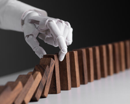 Robotic Hand Stopping Domino Collapse for AI Risk Management and Business Safety