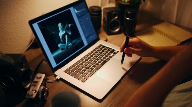 Male photographer retouch and editing digital photographs on laptop late at night, use photo editing software in dark workspace, representing creative post production and visual content creation