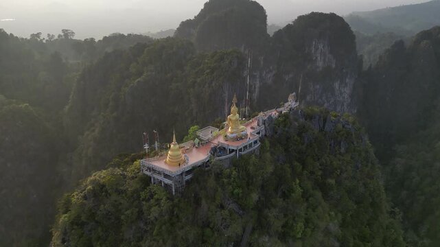 Golden Buddha Statue on Mountain Peak at Tiger Cave Temple in Krabi, Thailand