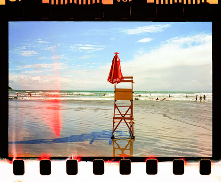 Lifeguard tower with folded umbrella on wet sand