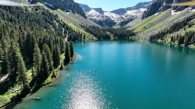 Aerial view of turquoise alpine lake and pine forest