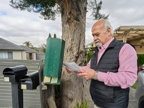 Senior Man Checks Mail at Mailbox