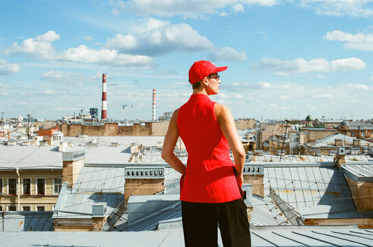 Person on Rooftop Overlooking City With Clouded Sky