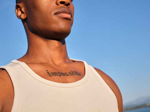 Young black man with impossible tattoo looking up