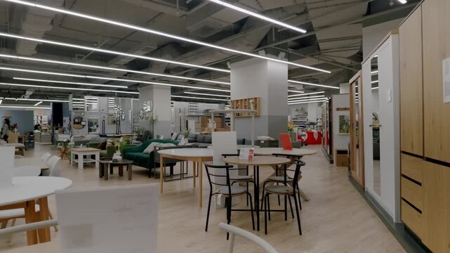 Spacious retail furniture showroom with a wide selection of modern chairs, tables, sofas, and beds. The store presents various interior design ideas for comfortable and stylish home living