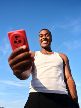 Young black man smiling making video call outdoors