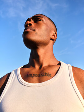 Determined man looking up with impossible tattoo