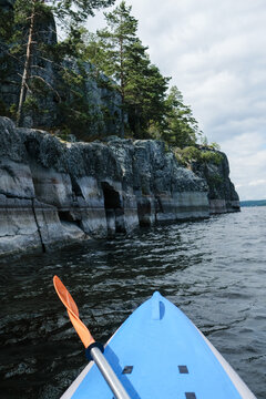 Kayaking Near Rocky Cliffs on a Cloudy Day in Nature