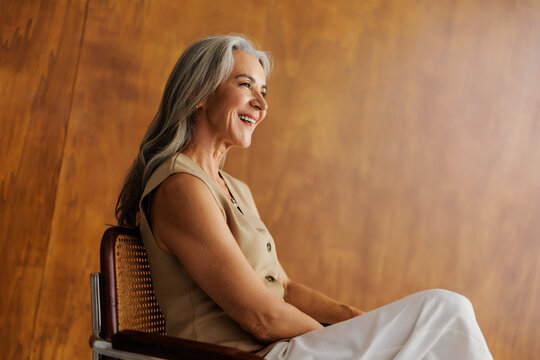 Senior woman smiling looking away with natural grey hair
