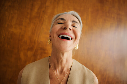 Senior woman laughing with joy and positive expression