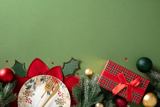 Christmas table setting with gift box and decorations on green background