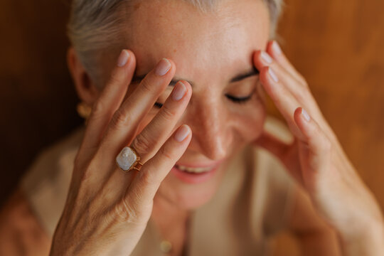 Woman smiling eyes closed wearing gemstone ring