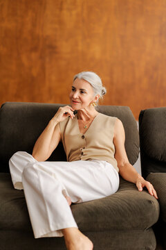 Senior woman relaxing on sofa thinking contemplating