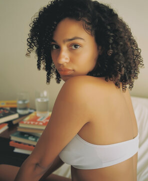 Intimate beauty portrait of a Black woman in a fine-rib modal bralette looking over her shoulder.