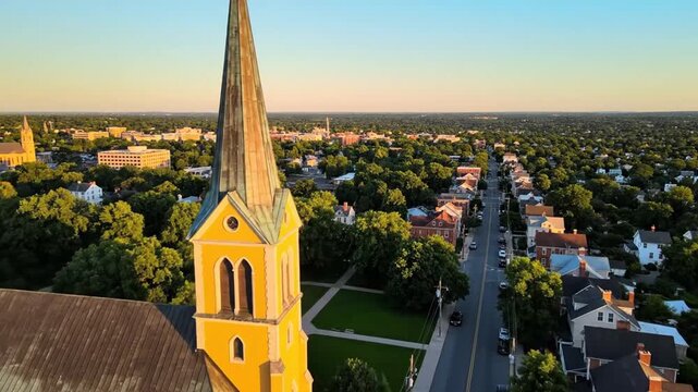 Aerial view of yellow church in residential neighborhood at sunset